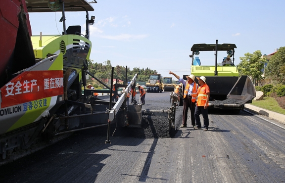 攤鋪機(jī)、壓路機(jī)等設(shè)備緊張有序運(yùn)行，高達(dá)170℃的瀝青混合料炙烤著公路人